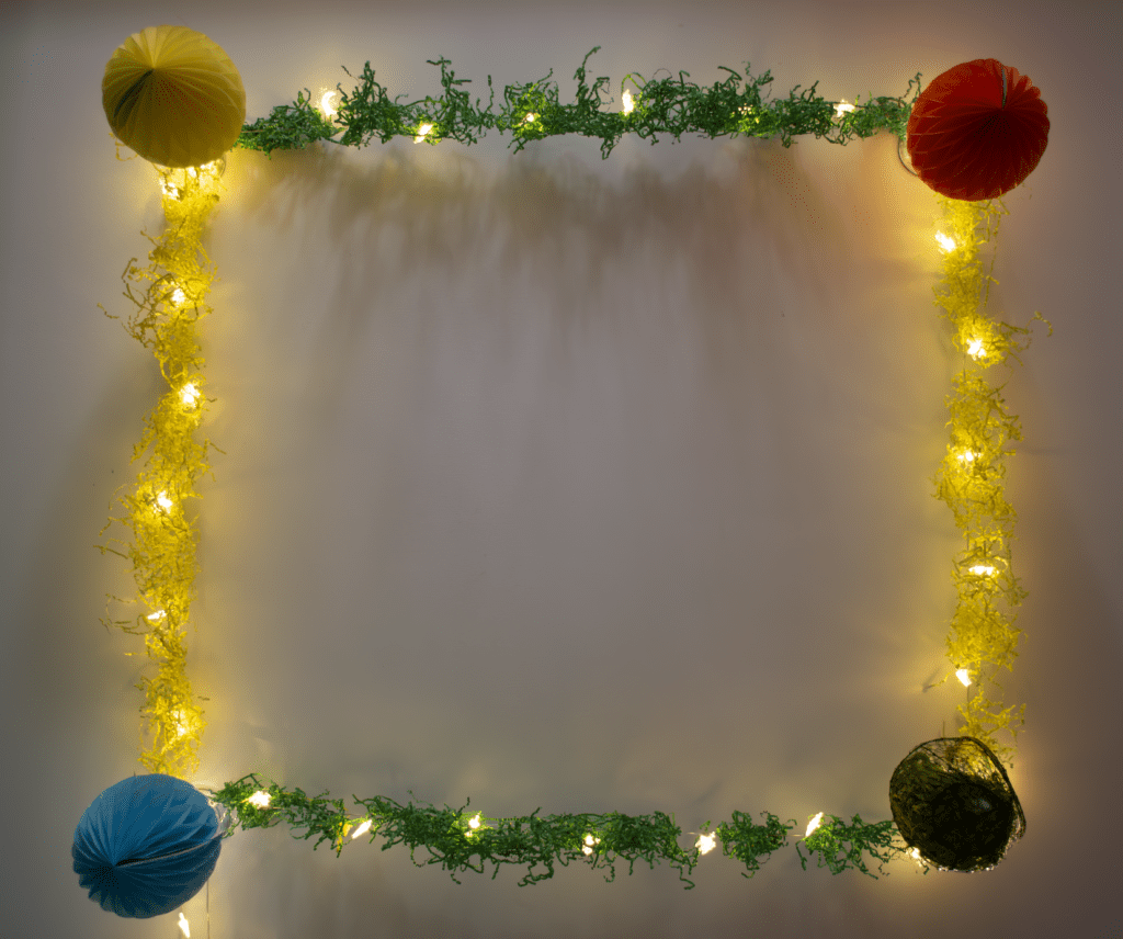 A frame of lights and paper lanterns on the wall.