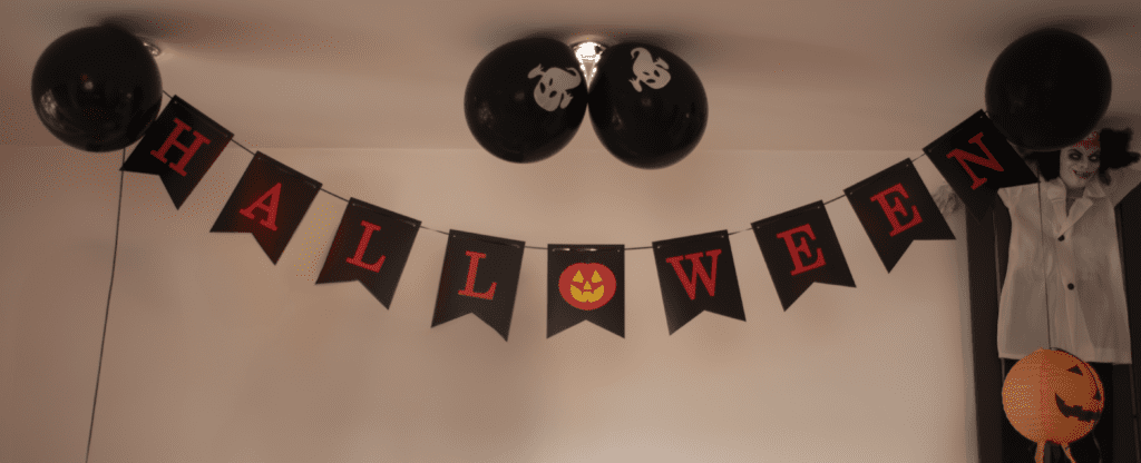 A black and red halloween banner hanging from the ceiling.