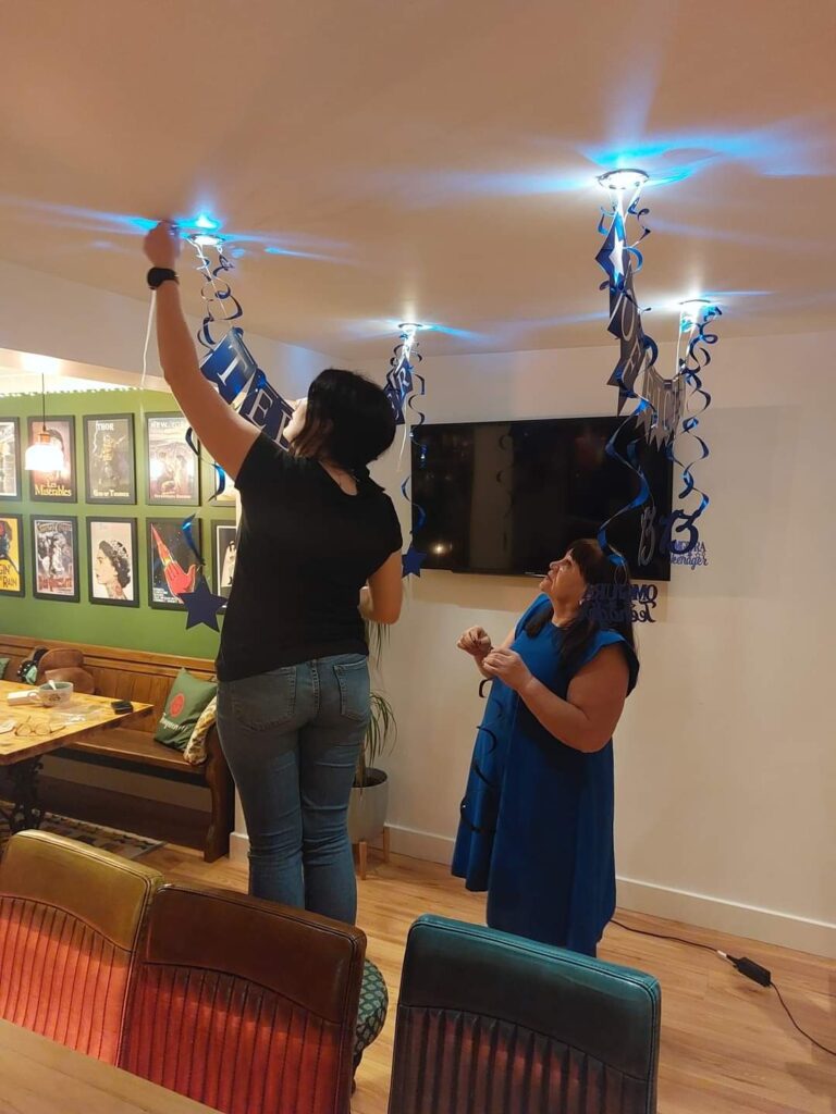 Two women are playing a video game in the living room.